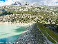 Der Blick geht über die Staumauer Richtung Bergsee-Hütte mit Schijenstock und Bergseeschijen. : Dammastock