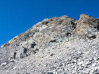 Nach dem Grat, der nicht sehr ausgesetzt ist, folgt eine kurze Geröllflanke und ich stehe vor dem Gipfelaufbau. Ich halte mich für den weiteren Aufstieg in gut gestuftem Fels mehr oder weniger an die vorhandenen Sicherungsstangen. Schwierigkeitsgrad ca. 2+.