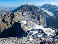 Blick zurück zur Aufstiegsroute. Der Ruchchälenpass befindet sich etwas links der Bildmitte, dort wo die von links unten heraufziehende, markante Schattenlinie endet. Von dort über den Ruchenfirn, dann in Aufstiegsrichtung rechtshaltend über Fels, nochmals etwas Firn, und dann in einer linkskurve auf den Ostgrat.