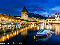 Es weihnachtet in Luzern: Die schön beleuchtete Kapellbrücke mit dem Wasserturm  spiegelt sich in der Reuss. Rechts im Bild die Jesuitenkirche und im Hintergrund das Wahrzeichen der Stadt - der Pilatus. : Beleuchtung, Luzern, Nacht, Weihnacht, Winter