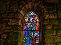 Fenster im Vorraum der Kirche, abgebildet ist der Hl. Andreas, Namensgeber der nahen Stadt und Patron Schottlands. (Im Wappen von Schottland ist das Andreaskreuz abgebildet, weiss auf blauem Grund.) : Dunino Den, Fort William, Forth Bridge, St. Andrews